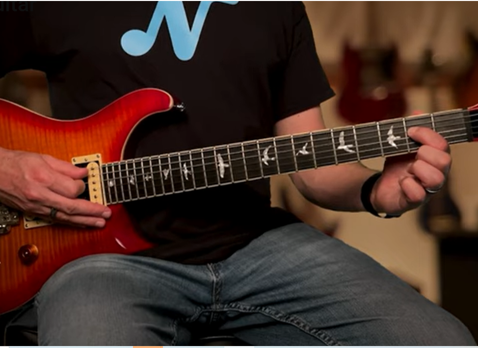 Dettaglio chitarra: dito indice al secondo tasto della quarta corda per l'accordo bicordo A5 (La quinta) Rock 'n' Roll.
